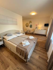 a bedroom with a large bed with two towels on it at AZUR Apartments Alsóörs in Alsóörs