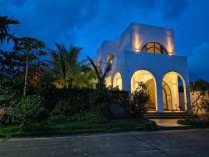 a white house with a lit up facade at night at LaiKa in Phú Quốc