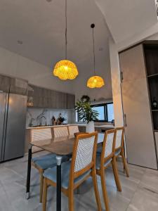 a kitchen with a table and chairs and two lights at LaiKa in Phú Quốc