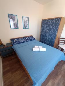 a bedroom with a blue bed with towels on it at Casa Alby in Nulvi