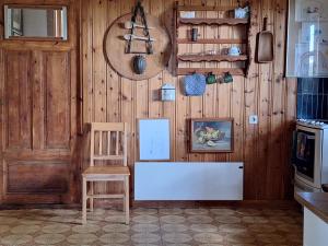 a room with a wooden wall with a bench and a chair at Gyllene tranans hus in Gammalstorp