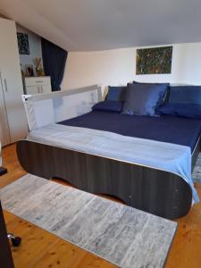 a large bed in a bedroom with blue pillows at La Bica in Bîrnova