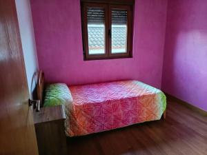 a bedroom with a bed in a pink room at Romanorum in Fermoselle