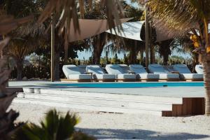 a swimming pool with blue and white lounge chairs at Sorobon Bay Hotel in Kralendijk