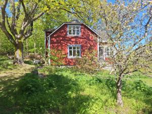 a red house with trees in front of it at Gyllene tranans hus in Gammalstorp