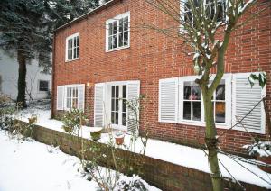 a red brick house with white windows in the snow at Ferienwohnung in Hamburg West in Hamburg