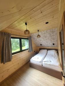 a bedroom in a log cabin with a bed at Dom z Widokiem na Tatry- Luxury Chalet in Klikuszowa