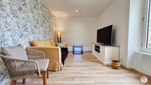 a living room with a couch and a tv at La Virée Champêtre in Villiers-Saint-Benoît
