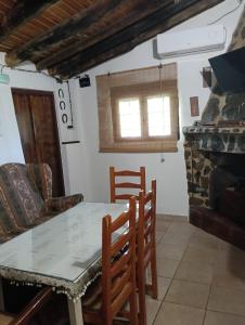 a dining room with a table and chairs and a fireplace at El rincón de Alájar in Alájar