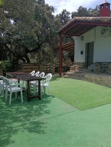 a wooden table and chairs on a green lawn at El rincón de Alájar in Alájar