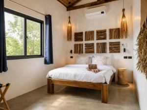 a bedroom with a bed and a window at DILAW Villa avec piscine privée in El Nido