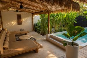 a patio with a couch and a hot tub at DILAW Villa avec piscine privée in El Nido
