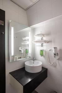 a white bathroom with a sink and a mirror at Hotel Woudschoten in Zeist +37 photos