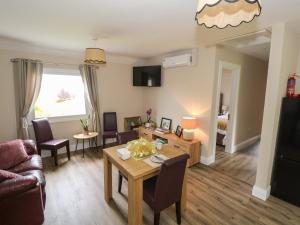 a living room with a table and a couch at Mayfly Cottage in Clonbur