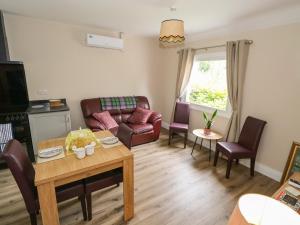 a living room with a couch and a table at Mayfly Cottage in Clonbur
