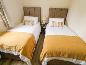 two beds sitting next to each other in a room at Mayfly Cottage in Clonbur