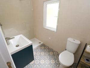 a bathroom with a white toilet and a sink at Mayfly Cottage in Clonbur +23 photos