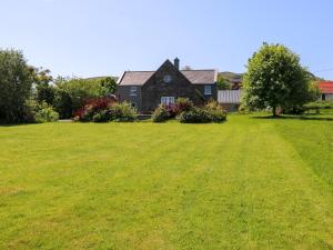 a large yard with a house in the background at Mayfly Cottage in Clonbur