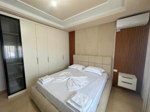 a bedroom with a bed with white sheets at Villa Preka in Durrës