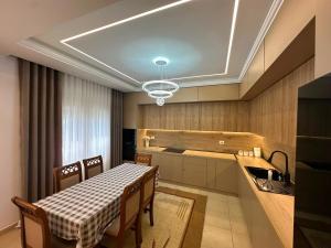 a kitchen with a table and some chairs and a table and a table at Villa Preka in Durrës