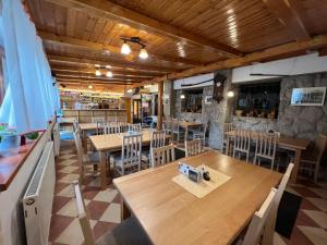 an empty restaurant with wooden tables and chairs at Penzion Stárek in Terchová