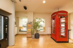 an old red phone booth in a room with a room with at Wombat's City Hostel Vienna Naschmarkt in Vienna
