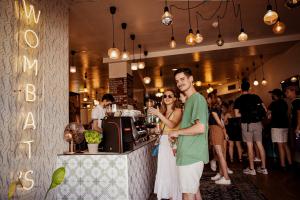 a man and a woman standing at a bar at Wombat's City Hostel Vienna Naschmarkt in Vienna