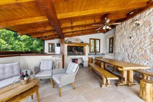 a patio with a table and chairs and a stone wall at Villa Evas Castle Crikvenica Riviera in Bribir