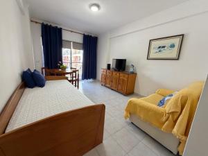 a bedroom with two beds and a couch and a table at Edificio Canoa in Armação de Pêra
