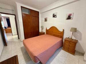 a bedroom with a bed and a wooden head board at Edificio Canoa in Armação de Pêra +8 photos