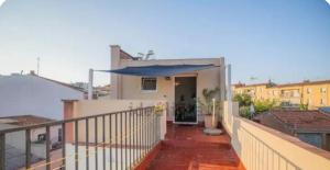 a balcony of a house with a blue umbrella at Under the Mediterranean sky in Terrassa