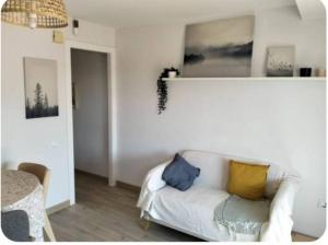 a living room with a white couch with pillows on it at Under the Mediterranean sky in Terrassa