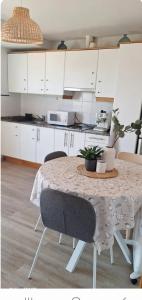 a kitchen with a table with chairs and white cabinets at Under the Mediterranean sky in Terrassa