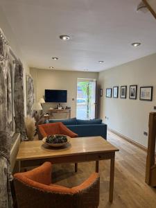 a living room with a table and a blue couch at The Feathers Hotel, Ledbury - The Coaching Inn Group in Ledbury