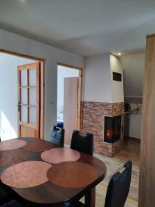 a room with a table and chairs and a fireplace at Domek Rosa in Bachlowa