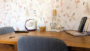 a wooden table with two chairs and a laptop on it at Les Chambres de Grangette in Thury