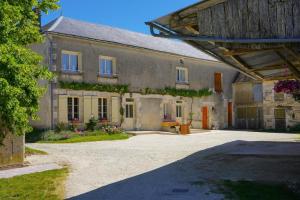 a large stone building with flowers growing on it at Les Chambres de Grangette in Thury