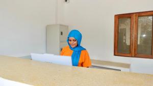 a woman with a blue hijab standing in front of a table at Maji Pearl Hotel & Spa in Nungwi +46 photos