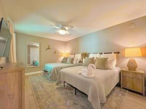 a bedroom with two beds and a flat screen tv at Vacation Villas #432 - Beachfront Condo in Fort Myers Beach