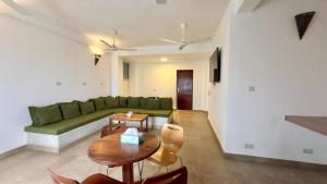 a living room with a green couch and a table at Maji Pearl Hotel & Spa in Nungwi