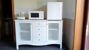 a white cabinet with a microwave on top of it at VianasHome in Amarante