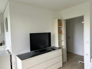 a living room with a flat screen tv on a dresser at Helles Apartment mit Self Check-in in Nuremberg