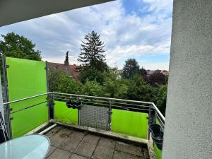 a balcony with a green wall and a table at Helles Apartment mit Self Check-in in Nuremberg