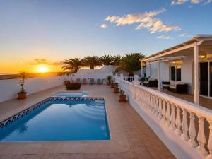a swimming pool on the balcony of a house with the sunset at La Ventana al Mar in Güime