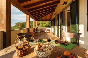 Una mesa con una cesta de comida en un porche. en Poggio La Croce, en Scarlino