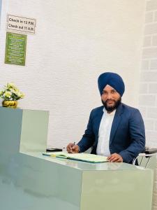 a man sitting at a table signing a document at Hotel Grand Royal Sandhu in Amritsar