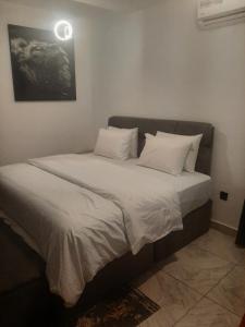 a bed with white sheets and pillows in a room at Jasper luxury homes in Abuja