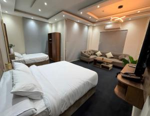 ein Hotelzimmer mit zwei Betten und einer Leinwand in der Unterkunft KH Hotel in New cairo