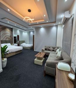 ein Hotelzimmer mit einem Bett, einer Couch und einem Tisch in der Unterkunft KH Hotel in New cairo