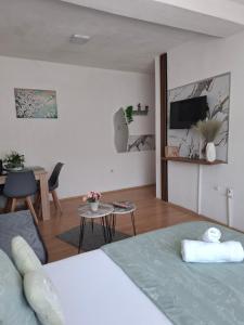 a bedroom with a bed and a living room at Happiness Apartment Skopje in Skopje